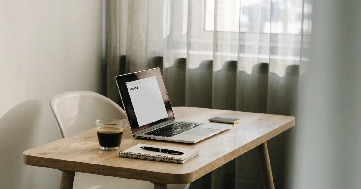 Freelancer's desk with an invoice open on a laptop — stripe fee calculator for processing fees and net payout
